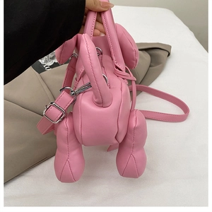 Detail view of pink balloon dog handbag showing smooth PU leather texture and shoulder strap