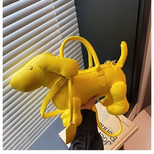 Detail view of a bright yellow dachshund puppy shaped creative leather handbag and strap