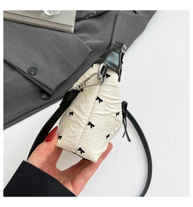 Gros plan d'un mini sac bandoulière avec motifs de nœuds noirs et finitions en cuir