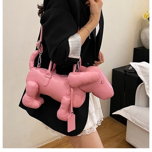 Close-up of pink dachshund-shaped handbag with glossy finish and detachable strap