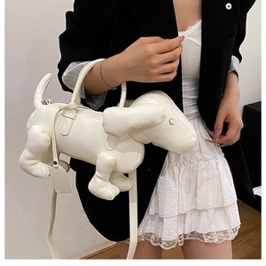 Detail einer kreativen weißen Handtasche in Hundeform, am Modell präsentiert