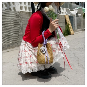 Handmade straw bucket bag with purple rope handle, lace edges and pearl pendant detail