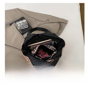 Vue détaillée de l'intérieur du sac à main à paillettes or rose avec rangement tablette