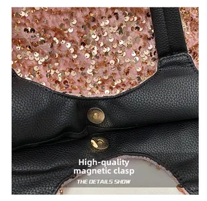 Détail du bouton pression magnétique doré sur sac en cuir grainé noir avec paillettes or rose