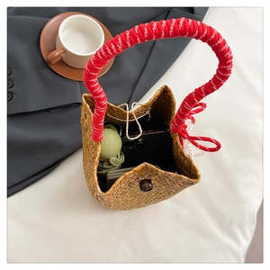 Detail view showing straw bucket bag interior with phone and green folding umbrella