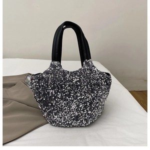Vue macro des paillettes argentées du sac cabas avec doubles poignées en cuir noir