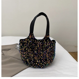 Vue détaillée des paillettes colorées d'un grand sac seau avec anse en cuir noir
