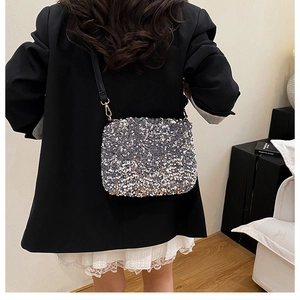 Détail du sac seau à paillettes argentées avec bandoulière en cuir et finitions dorées