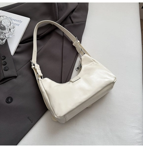 Detailed view of cream-white PU leather shoulder bag with silver hardware and metal buckles