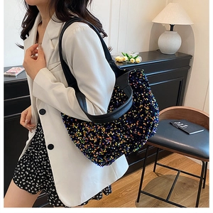 Détail d'un sac cabas à paillettes colorées avec lanières en cuir noir sur un mannequin