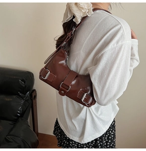 Brown vintage glossy underarm bag with silver buckles styled for a trendy commute
