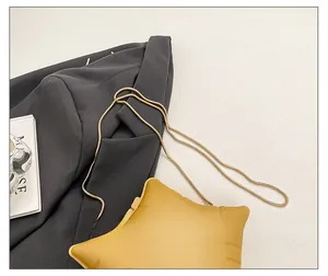 Detail of star-shaped crossbody bag with mustard leather and gold snake chain strap