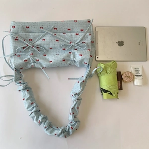 Flat lay of floral shoulder bag showing spacious interior with tablet and cosmetics