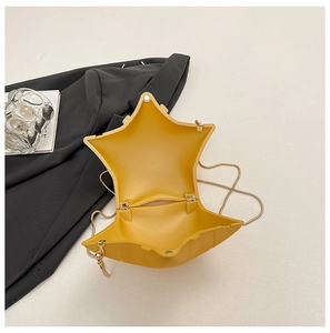 Détail d'un sac bandoulière en acrylique jaune en forme d'étoile avec chaîne dorée