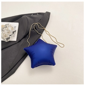 Détail du sac bleu en forme d'étoile avec une fine bandoulière en chaîne dorée