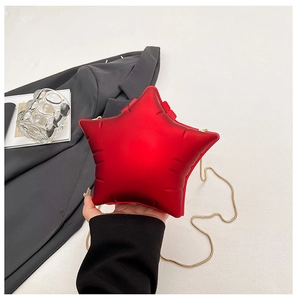 Détail du sac acrylique rouge en forme d'étoile avec texture matelassée et chaîne