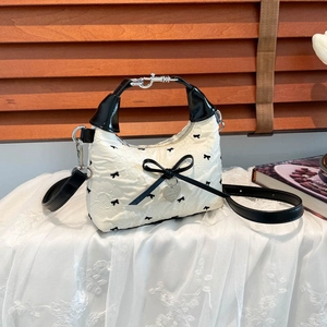 Sac bandoulière floral avec nœud noir et pendentif cœur sur dentelle blanche