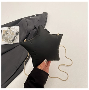 Détail du sac bandoulière étoile noire avec texture bouffante et chaîne dorée