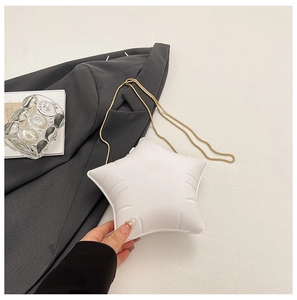 Détail du sac à bandoulière blanc en forme d'étoile avec texture matelassée et chaîne dorée