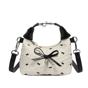 Sac bandoulière matelassé blanc élégant avec broderies noires et un nœud décoratif en cuir
