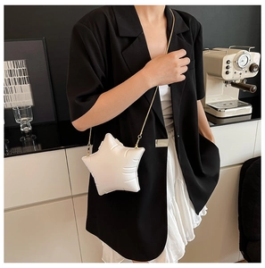 Sac bandoulière blanc en forme d'étoile avec chaîne dorée porté par un mannequin