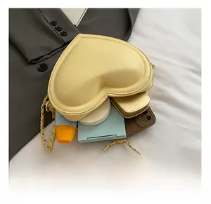 Detail view of heart-shaped bag interior capacity with metal chain strap