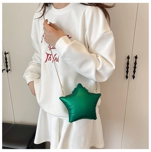 Close-up of matte green star-shaped crossbody bag with elegant gold chain strap