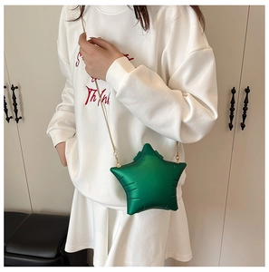 Détail du sac à bandoulière en forme d'étoile vert émeraude avec une chaîne serpent dorée