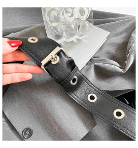 Close-up of black lychee leather strap with silver buckle and large metal eyelets