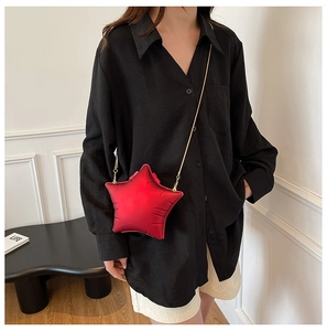 Détail du sac bandoulière rouge en forme d'étoile avec chaîne dorée et fini mat