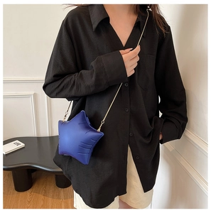 Detail of blue star-shaped acrylic crossbody bag with matte texture and gold chain strap