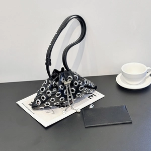 Detail of black leather bucket bag featuring silver metal eyelets and pearl drawstring accents