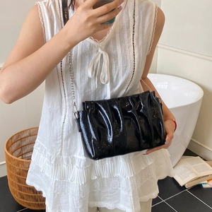 Sac nuage plissé noir minimaliste avec texture laquée brillante et chaîne argentée