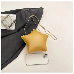 Vue détaillée du sac bandoulière jaune en forme d'étoile avec chaîne dorée et portable