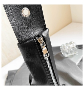 Detail of black pebbled leather texture with silver zipper and metal eyelet hardware