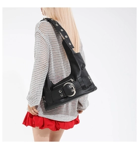 Détail du sac à bandoulière en cuir noir avec grande boucle argentée et œillets décoratifs
