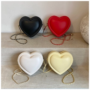 Detailed display of four colorful heart-shaped chain bags in black, red, white, and yellow