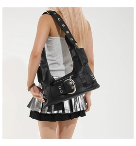 Detailed view of punk style black leather underarm bag with silver buckle and metal eyelets