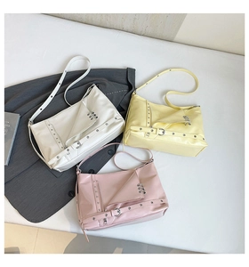 Dettaglio flat lay di borse tote stile moto Y2K in bianco, giallo e rosa con cerniere
