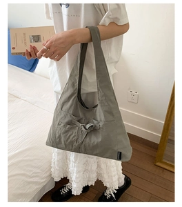 Gros plan sur le sac fourre-tout gris en toile avec poche avant à boucle chic