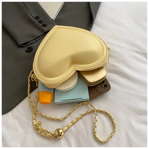 Interior view of heart-shaped crossbody bag showing storage for phone and cosmetics