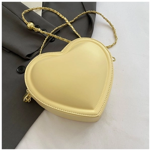 Detail of heart-shaped crossbody bag in pale yellow leather with gold chain strap