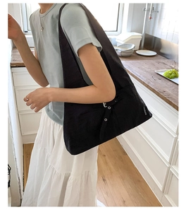 Gros plan sur un sac fourre-tout en toile noire avec poche latérale et fermoir