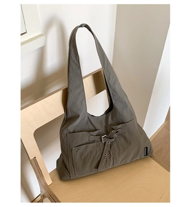 Détail du cabas en toile gris foncé avec poches et boucle métallique décorative