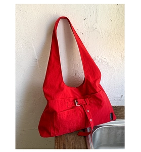 Détail du grand sac hobo rouge montrant la texture du tissu et les boucles en métal