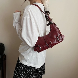 Vintage burgundy underarm bag with silver buckles shown on model in a casual outfit