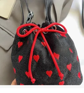 Detail of black glitter canvas bucket bag with red heart embroidery and drawstring