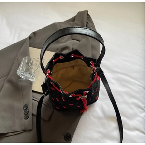Detailed top view of bucket bag interior with red heart embroidery and zip pocket