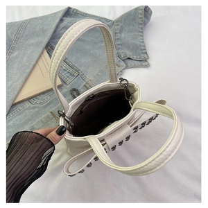 Detail of off-white punk crossbody bag featuring metal rivets and internal zipper pocket