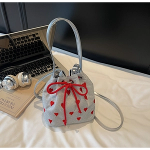 Detail view of silver sequin bucket bag with red heart embroidery and drawstring